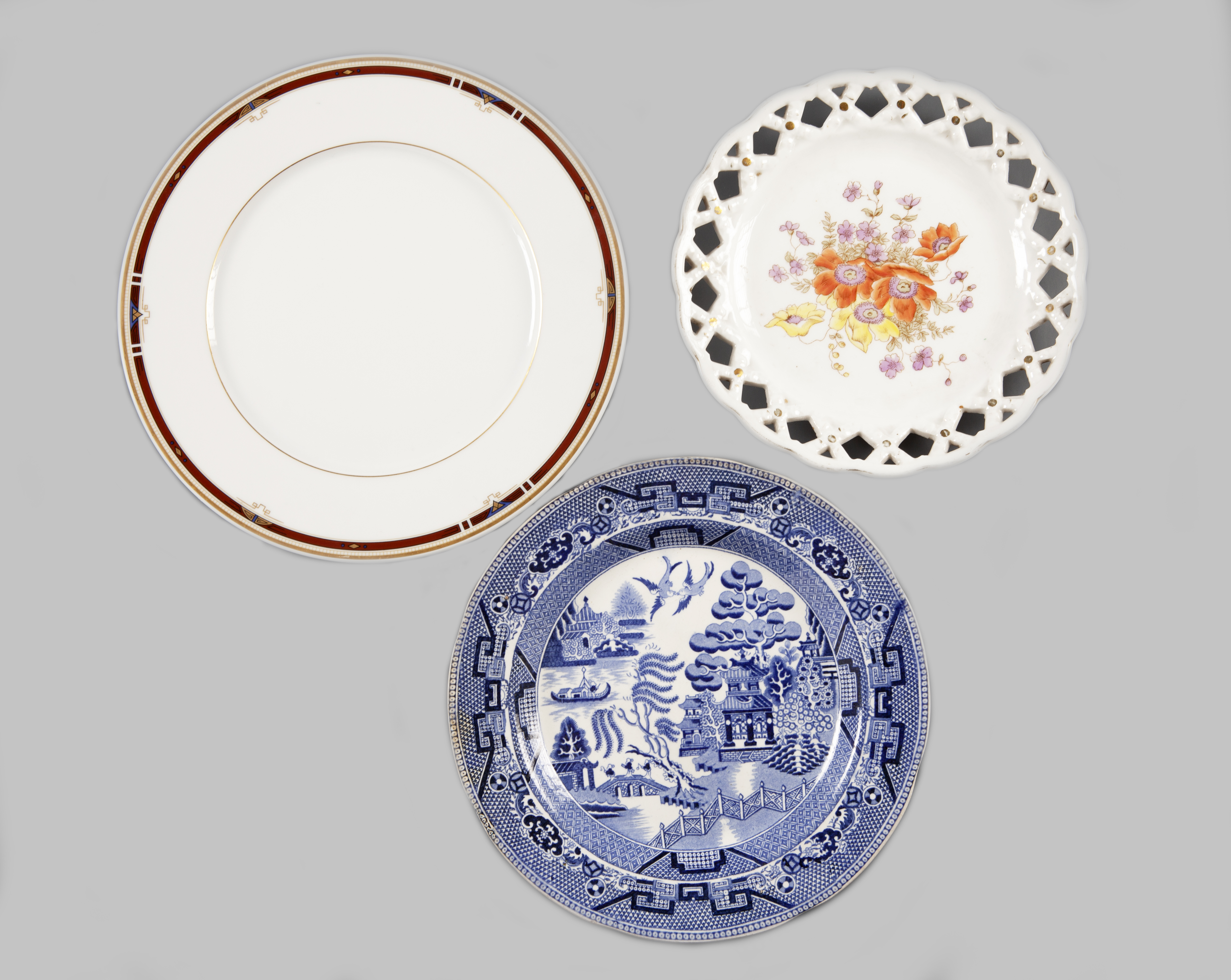 LOTE DE TRES PLATOS, DOS DE CERÁMICA Y UNO DE PORCELANA SIG