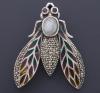 <span class='ref_item'>145 -</span>  <span class="description">BROCHE EN PLATA CON FORMA DE ABEJA COMPUESTO POR ZAFIROS NEGROS, RUBÍS, PIEDRA LUNA Y ESMALTE.Broche en plata con forma de abeja con piedra luna central, dos rubís recreando los ojos, esmalte de colores en ambas alas adornadas con zafiros negros.</span>  