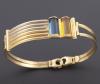 <span class='ref_item'>24 -</span>  <span class="object_title">PULSERA SEMIRIGIDA EN ORO BICOLOR DE 18 KT</span><br><span class="technical_description">Pulsera semirigida realizada en oro bicolor de 18 kt con dos piedras de color azul y ámbar respectivamente. <br/>Sistema de cierre mosquetón.</span>  