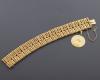 <span class='ref_item'>35 -</span>  <span class="object_title">PULSERA ANCHA CON MONEDA GRABADA EN ORO DE 18 KT.</span><br><span class="technical_description">Pulsera ancha realizada en oro de 18 kt. con barras trenzadas en oro liso y oro estriado con cadena de seguridad y colgando de un asa una medalla de Virgen (con diversas grabaciones) <br/> </span>  