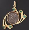 <span class='ref_item'>123 -</span>  <span class="object_title">COLGANTE EN ORO DE 18KT. CON ESMERALDAS Y CENTRO DE MONEDA </span><br><span class="technical_description">Colgante en oro de 18kt. con centro de moneda y esmeraldas en su talla con un peso total aprox de 1.00ct. </span>  