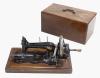 <span class='ref_item'>174 -</span> <span class="object_title">MÁQUINA DE COSER FRISTER ROSSMAN </span>   <p><span class="technique_material">Madera y metal</span><br><span class="technical_description">Máquina de coser marca Frister Rossman en metal lacado en negro con decoración dorada. <br/>En su estuche de madera con maquetería. <br/>Presenta deterioros. <br/>Con llave. </span><br></p>