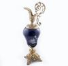 <span class='ref_item'>198 -</span> <span class="object_title">JARRÓN EN PORCELANA EN AZUL COBALTO, PRIMER TERCIO DEL S.XX.</span>   <p><span class="technical_description">Con incrustaciones de esmalte cloisonné a modo de ramillete floral y con mariposas. Representa un aguamanil con boca y base en bronce ricamente repujado con motivos vegetales. <br/>Presenta signos de oxidación</span><br><span class="ALTO_HCES1">62 </span><span class="ALTOUMED_HCES1">cm.</span></p>