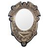<span class='ref_item'>275 -</span> <span class="description">ESPEJO DE VESTIDOR OVAL EN PLATA 925 DE INGLATERRA, 1918</span>  <p><span class="description">Espejo de vestidor realizado en plata con punzones ingleses de Mappin and Webb 1918, Birmingham, marcados en el ángulo inferior izquierdo. Está sobre una tabla forrada en terciopelo azul con soporte en la parte trasera para apoyar sobre superficie. Posee también un colgador para colocarlo en la pared.<br>Peso bruto total: 2291,9gr</span></p>