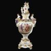 <span class='ref_item'>242 -</span> <span class="object_title">JARRÓN EN PORCELANA DE DRESDE, 1902</span>   <p><span class="technique_material">Porcelana </span><br><span class="technical_description">Jarrón realizado en porcelana de Dresde ricamente decorado con motivos florales aplicados distribuidos por su doble base, cuerpo y tapa. Con detalles delineados en dorado. Escena central de inspiración clásica, enmarcada por una guirnalda de flores y custodiado por dos damas en laterales portando cestas en sus regazos.<br/>Tapa decorada con el escudo de armas sajón-polaco rodeado por querubines y rematado por una corona real.<br/>Sello azul "SP DRESDEN" en la base perteneciente al periodo de fabricación de 1902.</span><br><span class="ALTO_HCES1">84</span>x<span class="ANCHO_HCES1">36</span>x<span class="GRUESO_HCES1">31 </span><span class="GRUESOUMED_HCES1">cm.</span></p>