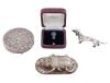 <span class='ref_item'>243 -</span> <span class="object_title">LOTE DE 4 OBJETOS EN PLATA 800 M/M</span>  <p><span class="technical_description">- Colgante en forma de escarabajo<br/>- Reproducción de perro salchicha<br/>- Polvera con espejo y repujada con motivos florales<br/>- Pin esmaltado de escudo.<br/>Peso total bruto: 181,1gr</span><br></p>