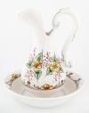 <span class='ref_item'>149 -</span> <span class="object_title">AGUAMANIL Y JOFAINA EN PORCELANA CON DECORACIÓN PINTADA A MANO (S.XX)</span>   <p><span class="technical_description">El juego de ambas piezas presenta una vistosa decoración de estilo rústico provenzal, ejecutada con pintura polícroma a mano alzada. Destacan los motivos de ramilletes de flores silvestres en un vivo tono amarillo acompañados de hojas verdes.<br/>El cuerpo de la jarra presenta fino 'pelo' en el esmalte. Medidas aguamanil: 29.5cm altura. Medidas jofaina: 28cm de diámetro.</span><br></p>