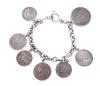 <span class='ref_item'>187 -</span> <span class="object_title">PULSERA EN PLATA DE LEY 925 CON COLGANTES DE MONEDAS</span>  <p><span class="technical_description">Pulsera realizada en plata de ley 925 formada por cadena de eslabones ovales rolo, con adorno colgante de siete monedas (reproducciones), de diferentes tamaños y motivos.<br/>Cierre de pasador. Longitud: 19 cm</span><br>Peso: <span class="PESO_HCES1">58</span> <span class="PESOUMED_HCES1">gr.</span><br></p>